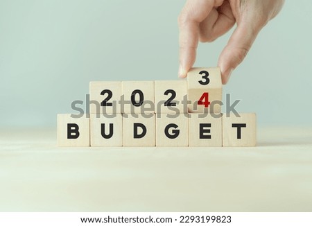 2024 Budget planning and allocation concept. Hand flips wooden cube and changes the inscription 
