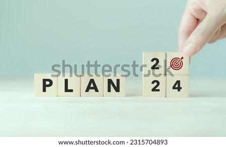 2024 Goal plan action, Business plan and strategies. Business annual plan and development for achieving golas. Goal acheiveement and success in 2024. Placing the wooden cubes with 2024 goals icons.