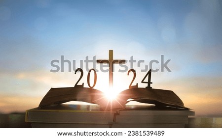 2024 new year and cross of jesus christ on open holy bible with sunrise background
