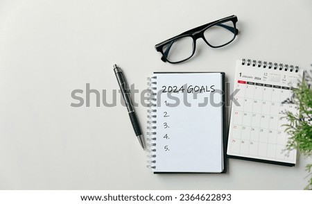 2024 New Year goal, plan, and action concepts. 2024 goals Text on Note Pad with calendar, glasses on the table.New Year's resolutions plan.Happy New Year theme, top view, copy space.