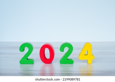 2024 standing colored block numbers on light wooden and white background - Shutterstock ID 2199089781