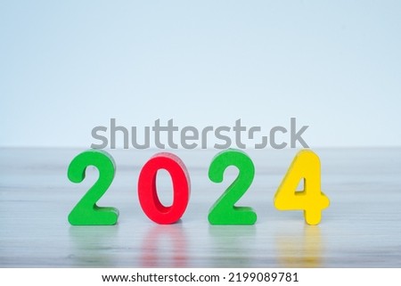 2024 standing colored block numbers on light wooden and white background