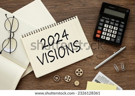 2024 visions top view on notebook stickers calculator and paper clips.text on page
