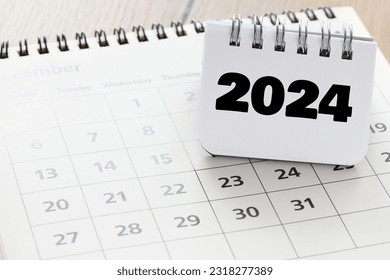 2024 year written in a notebook on a calendar.. 2024 plans with digital marketing concepts,business team and goals