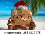 2025 New Year Vacation on a Tropical island. Tourist man with Santa Claus hat and old treasure map. Punta Cana beach, Dominican Republi