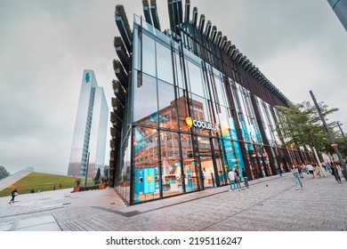 21 July 2022, Dusseldorf, Germany: Cityscape With Ko Bogen II Famous Architecture Building. It Is Popular Sightseeing, Business And Shopping Center. People Walking By Pedestrian Street Among Shops