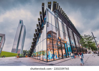 21 July 2022, Dusseldorf, Germany: Cityscape With Ko Bogen II Famous Architecture Building. It Is Popular Sightseeing, Business And Shopping Center. People Walking By Pedestrian Street Among Shops