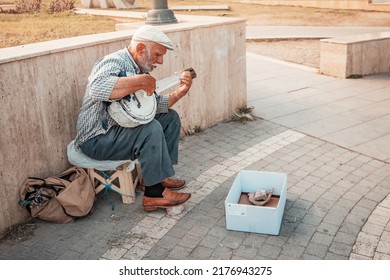 21 June 2022, Antalya, Turkey: Senior Man Playing On Folk Traditional Musical Instrument - Saz And Begging For Money At City Street