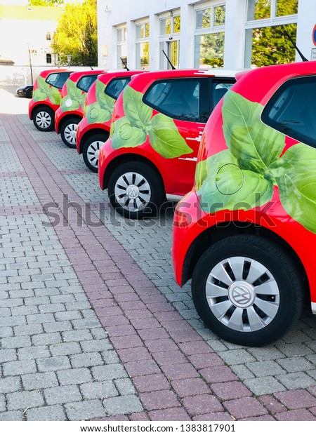 21.04.2019 Bautzen Saxony\
Germany. red cars with a green leaf of basil stand in a row in the\
parking lot