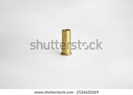 .22 LR caliber empty casing. Used brass bullet case on white empty backgroung. Close up side view