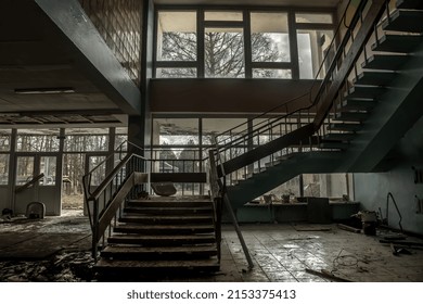 22.04.2022. Moscow. Russian Federation. Beautiful dark hall with an old staircase. An old abandoned building. Dirty shabby walls and steps. Large transparent windows. Old creepy abandoned building.