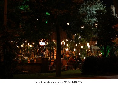 22.10.2019 - Antalya, Turkey. Outdoor dining restaurant at night. View of outdoor dining area at night. Beautiful bulb illumination in the garden. Cozy atmosphere.