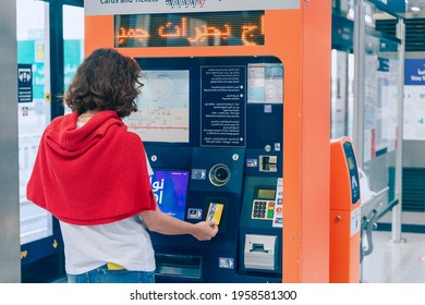 23 February 2021, Dubai, UAE: a female passenger replenishes her transport card for a tram or metro in Dubai using an automatic cash register