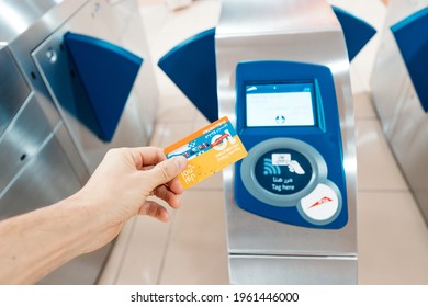 23 February 2021, Dubai, UAE: Tapping nol metro card at turnstile and paying for transportation