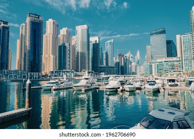 23 February 2021, Dubai, UAE: Yacht And Motor Boats Parking At The Port Near Dubai Marina Mall With Row Of High Skyscrapers Residential Buildings And Hotels