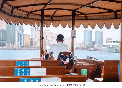 23 February 2021, Dubai, UAE: Young man works as a driver and captain of a wooden abra dhow boat in the Bur Dubai Creek area and transports passengers from one side of the channel to the other