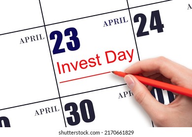 23rd day of April.  Hand drawing red line and writing the text Invest Day on calendar date April 23.  Business and financial concept. Spring month, day of the year concept.