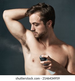 24 Hour Protection. Cropped Shot Of A Handsome Young Man Spraying Deodorant On His Armpit.