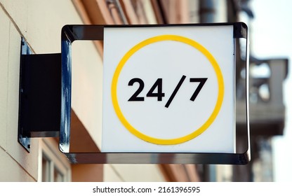 24 Hours Open Sign Or Working Around The Clock Sign Hanging On Wall. Working 24 Hours, Sign On Facade Of Building.