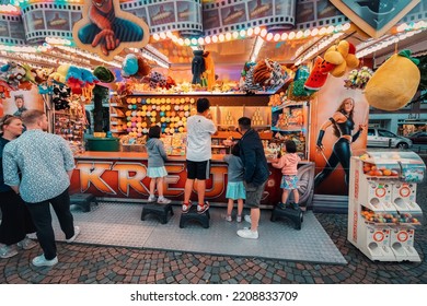 24 July 2022, Osnabruck, Germany: A Family With Children Have Fun In A Game Dash, And Blow Up Balloons Trying To Win Prizes