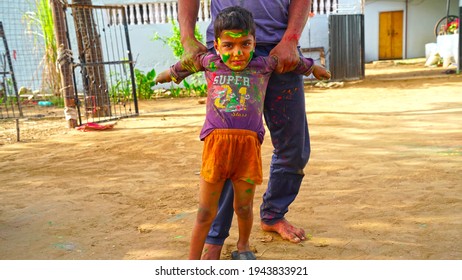 24 March 2021- Khatoo, Jaipur, India. Family Celebrating Holi In The Park. Beautiful Rural Scene Of Indian Father And Little Son Playing Holi.