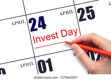 24th day of April.  Hand drawing red line and writing the text Invest Day on calendar date April 24.  Business and financial concept. Spring month, day of the year concept.
