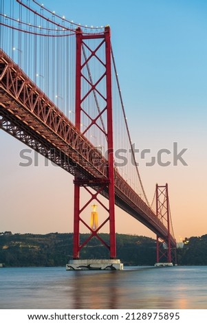 The 25 de Abril bridge over the Tajo River with Cristo Rei or Christ the King in the background. Lisbon. Portugal