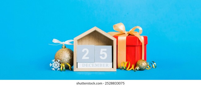 25 december. Christmas composition on colored background with a wooden calendar, with a gift box, toys, bauble copy space. - Powered by Shutterstock