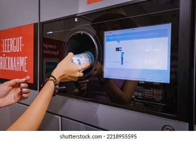 25 July 2022, Munster, Germany: A Student Girl Hands Over A Plastic Beverage Bottle For Recycling To Automated Machine. Eco Friendly Lifestyle And Cashback