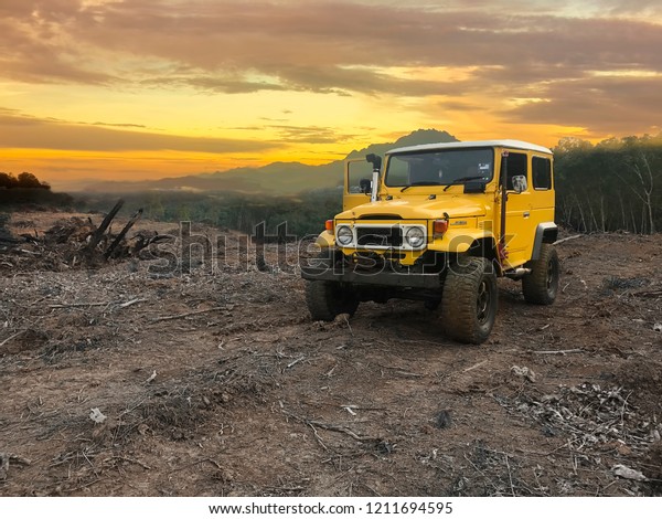 25
October 2018 , Sabah, Malaysia, Yellow Toyota Land Cruiser FJ40
with off road modification park in top hill in Kota Kinabalu ,
Sabah .Beautiful view of mount Kinabalu In
background.