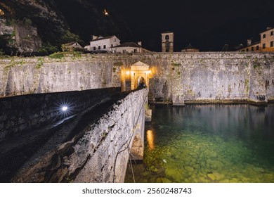 25 October 2024, Kotor, Montenegro: Bridge leading to the illuminated entrance of Kotor fortress at night - Powered by Shutterstock