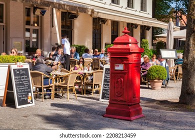 25 September 2018: Bruges, Belgium - Customers Sitting Outside A Tea Room, And A Red Mail Box, In The Historic Heart Of The Old City.