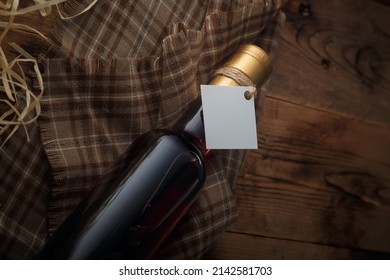 250 ml bottle of red wine with blank label on wooden shavings background. Cabernet sauvignon, merlot. Copy space