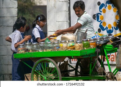 25.03.2019 Durgapur, West Bengal, India : Village School kids are getting street foods from the seller during tiffin time in front of school gate.