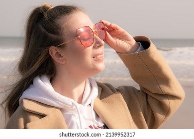 25.03.2022 Qingdao, Shandong, China. A Girl Wearing Gucci Glasses On A Beach On A Sunny Day 