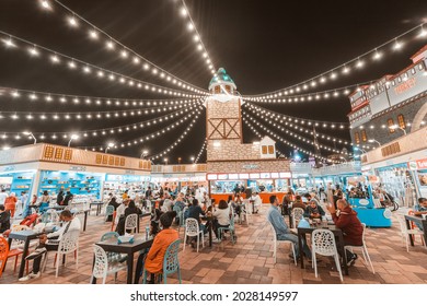 26 February 2021, UAE, Dubai: Many people tourists relax and have dinner in a Turkish cafe near the famous Maiden Tower in the Global Village
