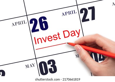 26th day of April.  Hand drawing red line and writing the text Invest Day on calendar date April 26.  Business and financial concept. Spring month, day of the year concept.