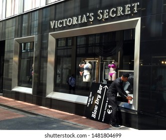 26th July 2019, Dublin, Ireland. Man With A Blow Dry Bar Hair Salon Sign Outside A Victoria's Secret Store On Grafton Street, Dublin City Centre. 