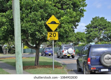 27 April 2018. Illustrative Editorial. Coffs Harbour, Australia. Moving Traffic On 20 Km Speed Limit Street. Road Sign Post With 20 Km Per Hour And Speed Bump.