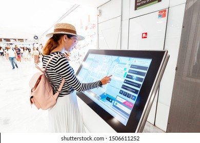 28 July 2019, Paris, France: Asian Girl Uses Touchscreen Terminal To Find The Right Boutique In A Big Shopping Mall