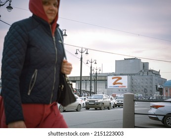 28th Of April 2022, Russia, Tomsk, Billboard With Z Letter On The Building And Passerby On Street