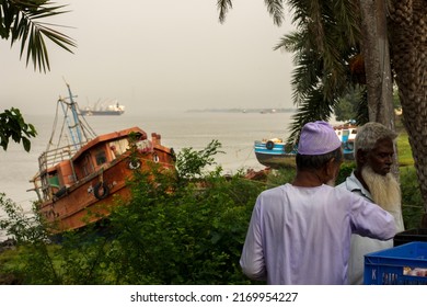 28th May, 2022, Diamond Harbour, West Bengal, India: Two Muslim Old Fisher Men Having Morning Tea And Discussing About Fishing Trip And Fishing Boat In Background. Selective Focus.