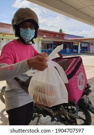 29.1.2021, Kuala Lumpur, Malaysia: A Foodpanda Deliverer Is Handing Out Food Orders To Customers. Mobile Food Delivery Services Received Encouraging Response During Pandemic Covid 19.