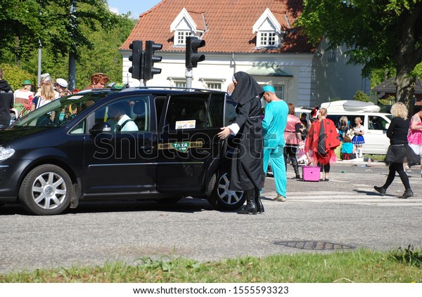 29th of May 2010 -Scene from a Danish city during the\
yearly carnival with a person dressed up as a nun entering a taxi,\
Aalborg, Denmark 