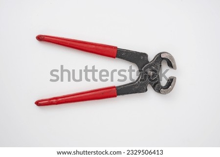2nd hand pliers with a red plastic handle on a white isolated background                               