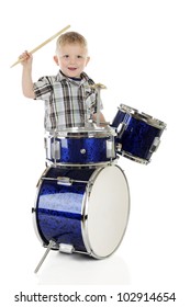 A 2-year-old Happily Playing A Set Of Shiny Blue Drums.  On A White Background.