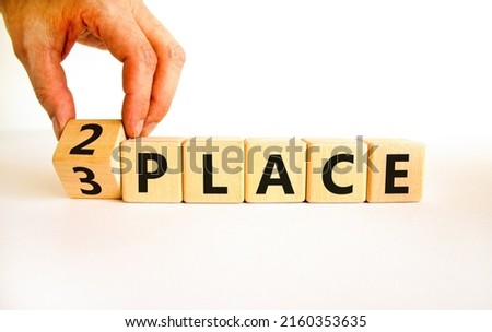 From 3 to 2 place symbol. Businessman turns wooden cubes and changes concept words 3 place to 2 place. Beautiful white table white background. Business and from 3 to 2 place concept. Copy space.