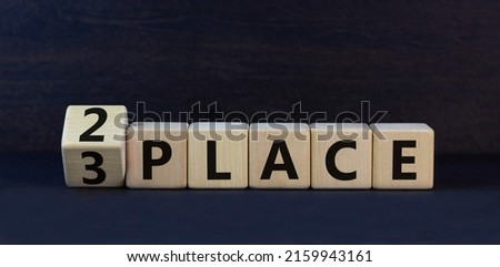 From 3 to 2 place symbol. Turned wooden cubes and changed concept words 3 place to 2 place. Beautiful black table black background. Business and from 3 to 2 place concept. Copy space.