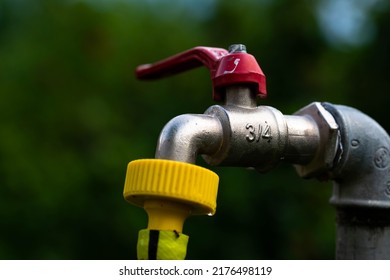 3, 4 Inch Garden Water Tap With Yellow Hose Close Up Macro Shot.