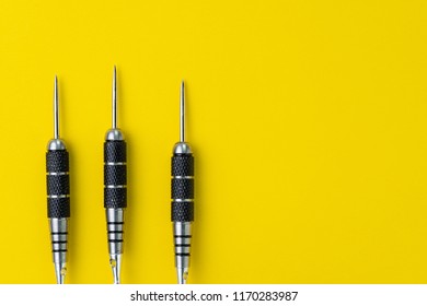 3 Black Darts Flat Lay On Solid Yellow Background With Copy Space Using As Target And Goals Or Three Best Important Things You Need To Know Concept.